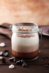 Delicious vanilla-chocolate mousse on wooden background, close up