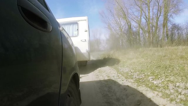 Dusty road of car with  caravan, trailer.