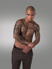 shirtless man with tattoos posing.