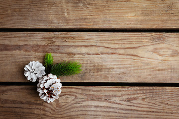 Beautiful simple winter background with pine cones on wooden texture