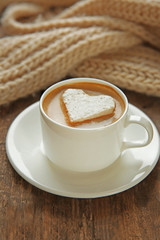 Cup of coffee with marshmallow on wooden table