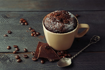 Chocolate fondant cake in cup on wooden background