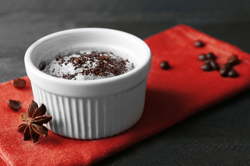 Chocolate fondant cake in cup on wooden table closeup