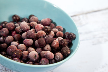 Frozen blueberries on light blue wooden background