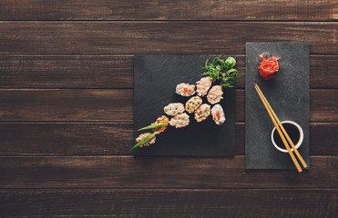 Set of sushi maki and rolls at black rustic wood. © Prostock-studio