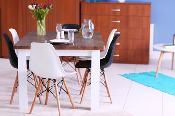 Modern living room. Furniture set with table and chairs. Bouquet of beautiful white and purple tulips on the table