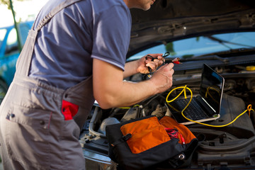 Fototapeta na wymiar Professional car mechanic working in auto repair service, using