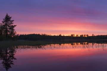 red and pink sunrise on the calm lake in the morning