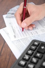 Man filling American form of Individual Income Tax Return at the table