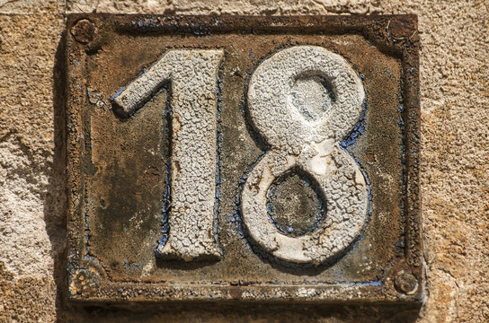 Old retro weathered cast iron plate with number 18