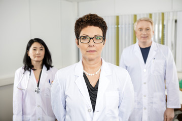 Fototapeta premium Confident Female Doctor Standing With Colleagues