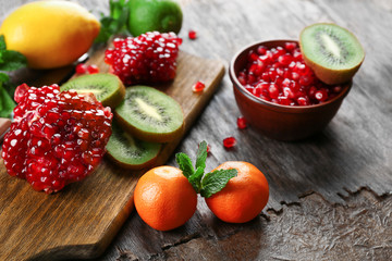 Juicy tropical fruits on wooden board, close up