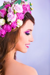 Beautiful young woman wearing floral headband on a grey background