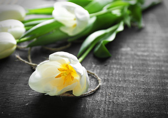 Bouquet of white tulips on black wooden background