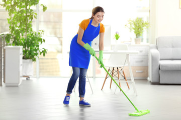 Woman cleaning floor with mop indoors