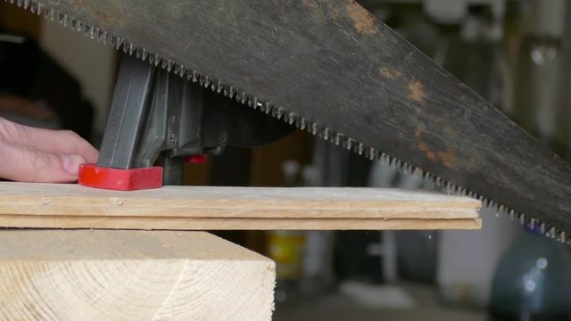 sawing of wooden plank using hacksaw