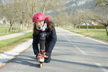 Fototapeta premium pretty preteen girl on roller skates in helmet at a track