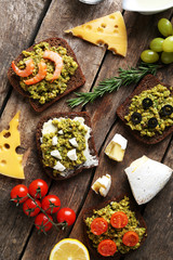 Avocado sandwiches with vegetables on dark wooden background