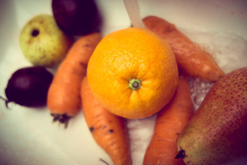 Raw vegetables mixed concept, carrots, potatoes, radish and orange as seen from above