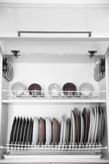 Clean dishes drying on metal dish racks on shelves