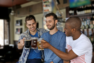 Group of happy friends drinking beer in pub