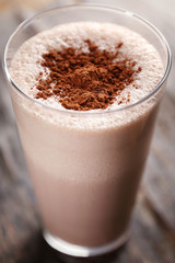 Delicious milk cocktail on rustic background, close up