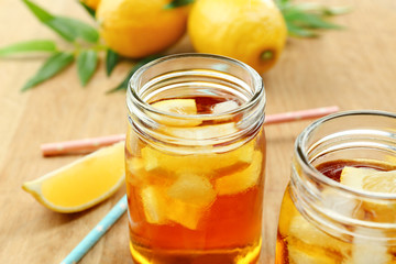 Fototapeta na wymiar Jar of ice lemon tea with straw on wooden table