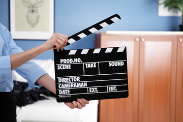 Woman hands holding film clapper, close up