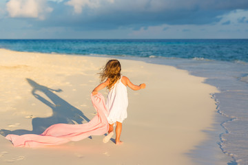 Fototapeta premium Little girl playing on beautiful ocean beach