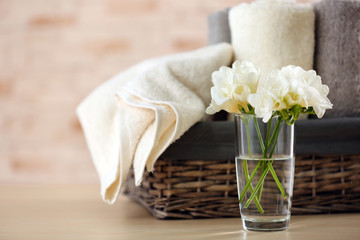 Fototapeta na wymiar Towels and flowers on table