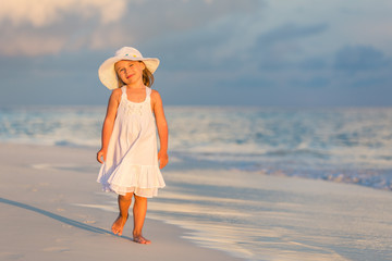 Little girl walking on beautiful ocean beach