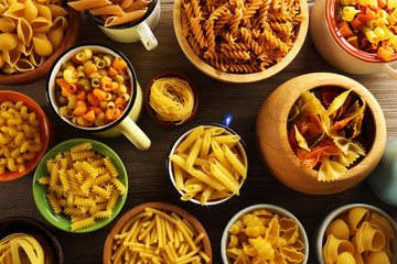 Various types of pasta in dishes, top view