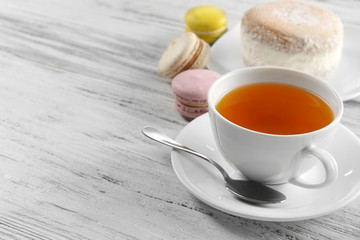 Cup of tea with delicious cake and macaroons