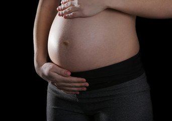 Pregnant woman on black background