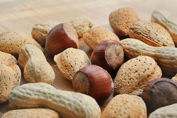 Almonds, hazelnuts and peanuts on a wooden board