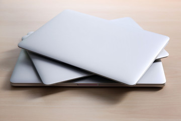 Stack of laptops on wooden table