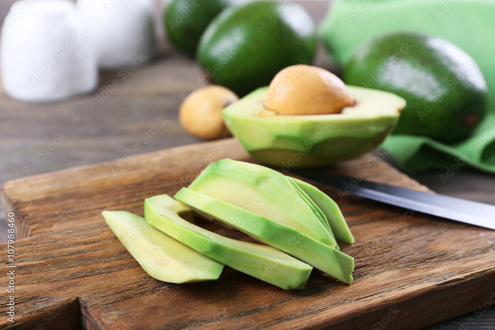 Poster fresh sliced avocado on cutting board, close up