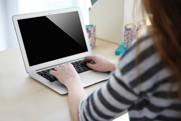 Woman working with laptop at home or at office