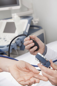 Doctor taking blood pressure of senior woman