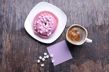 Cup of coffee, doughnut, marshmallows and blank piece of paper on wooden background