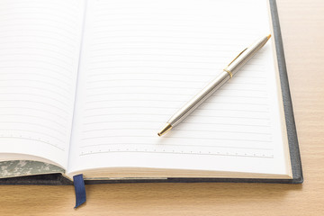 Pen put on notebook open blank page