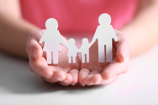 Female hands holding white family figures