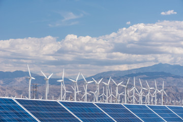 Solar panels and wind turbines in sunny desert