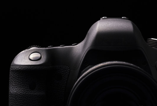 Professional modern DSLR camera low key image - Modern DSLR camera with a very wide aperture lens on
