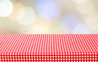Empty red check table cloth over blur abstract bokeh background