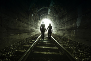 Couple walking together through a railway tunnel