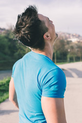 Focused handsome athlete resting after long run