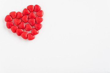 Red heart candy in a heart shape on a white background
