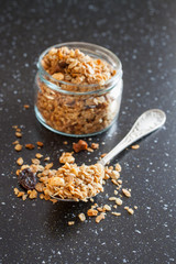 muesli in a spoon from a jar on a table, selective focus