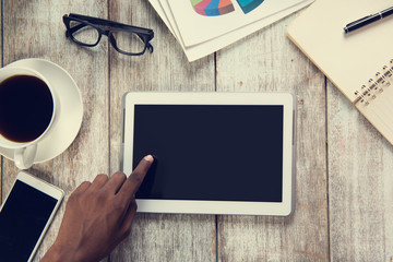 Tablet computer in male hands, cup of coffee, organizer, laptop